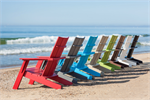A line up of Contemporary Adirondack Chairs on a beach in 8 colors.