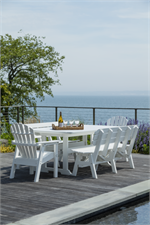 Seaside Casual White Poly Dining table by the pool over looking the water.